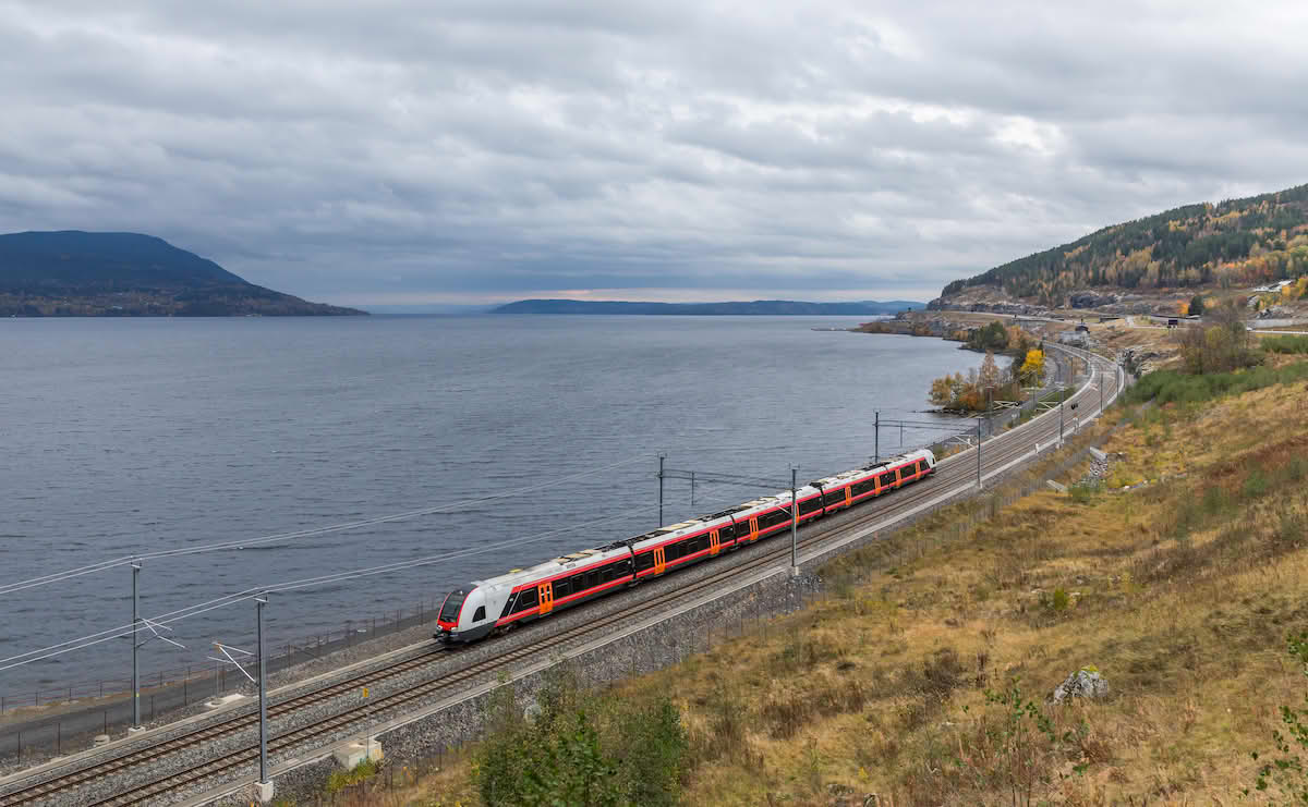 Vy tog som kjører langs Mjøsa ved Espa på vei mot Lillehammer